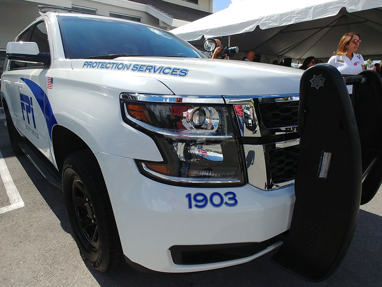 Front of FPI Security Services SUV vehicle on a sunny day.