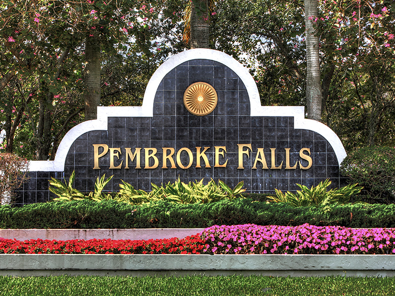 picture of pembroke falls logo of the community sign. The color of the wording is gold and the backdrop is black.