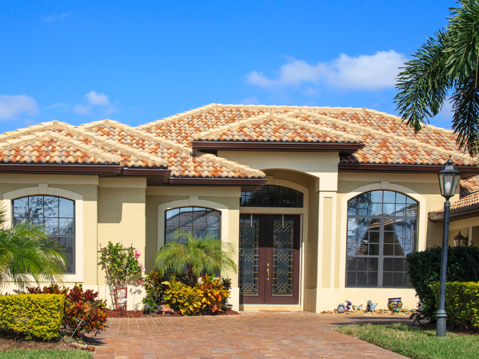There is a picture of a house located in weston florida that depicts the community in the blog,. There is a bright blue sky and nice yellow house with tile roofing.