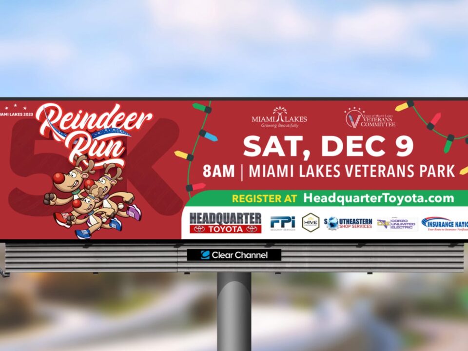 Picture of a red digital billboard that says reindeer run 5lk with 3 reindeer on the left side of the design. THere is also on the right hand side wording that says sat, dec 9 aam miami lakes veteran's park register at headquartertoyota.com. There is also a list of sponsors on the sign as well.