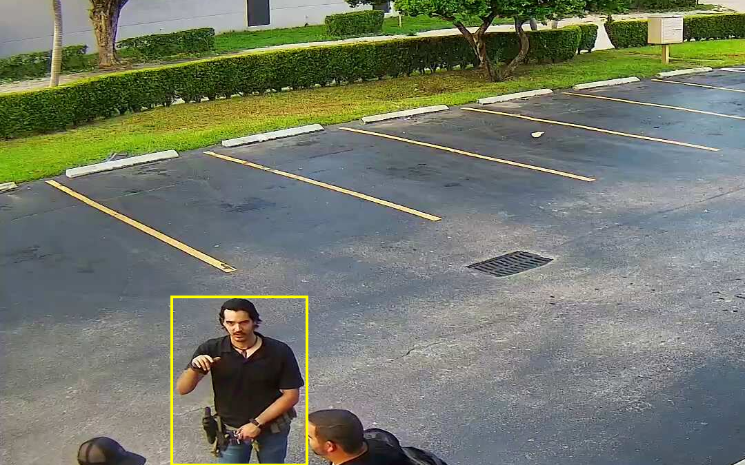 This is an image of 3 men wearing black shirts and jeans talking in the parking lot of Florida gun center located in Hialeah florida.